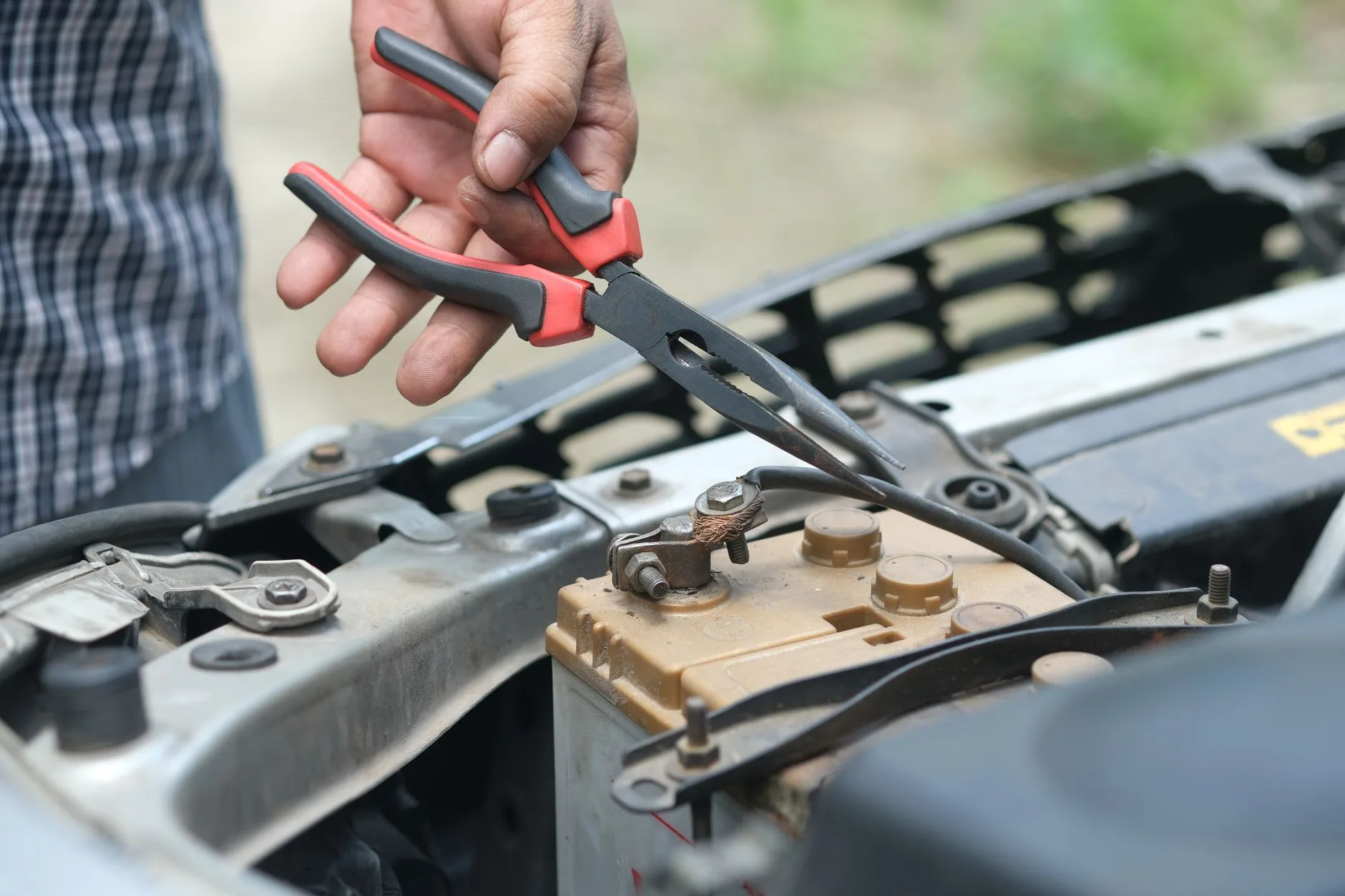 Mesure au multimètre sur une batterie voiture qui se décharge pour détecter une fuite de courant
