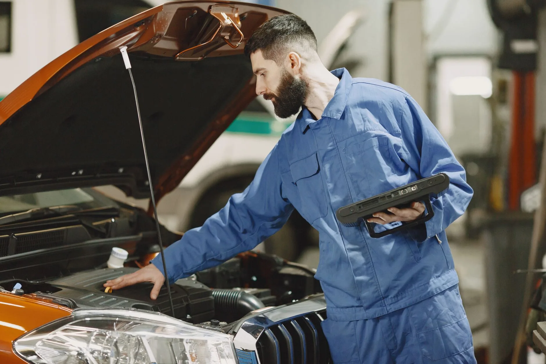 Mécanicien diagnostiquant un ralenti instable sur un moteur de voiture, capot ouvert